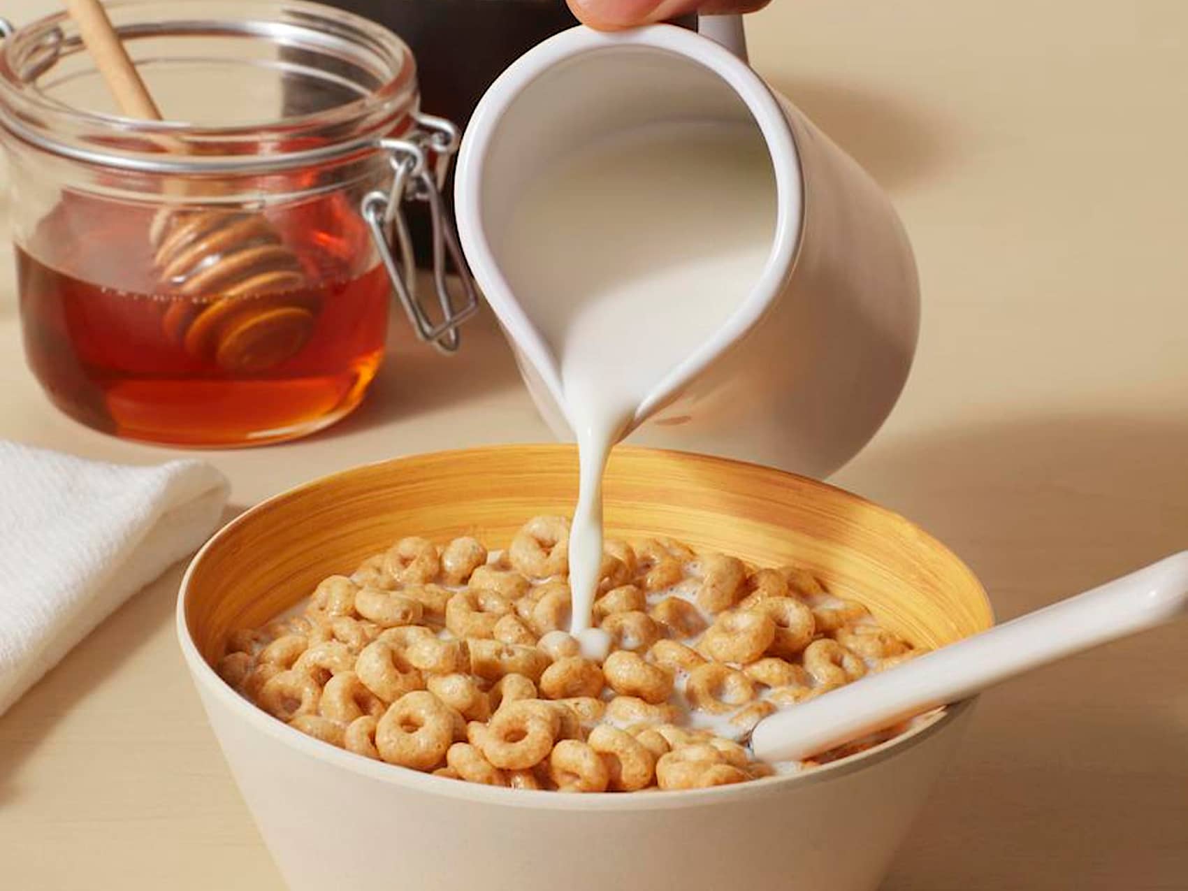 Milk being poured into bowl of Cheerios